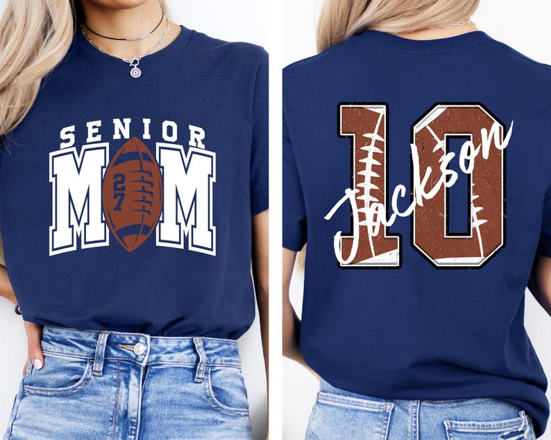 May include: A navy blue t-shirt featuring a front graphic with the text SENIOR MOM and a brown football with the number 27. The back graphic displays the number 10 in a brown football texture with the name Jackson written in white script across it.