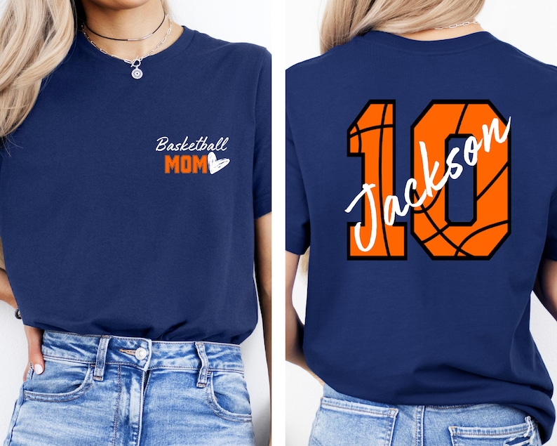Peut inclure: Un t-shirt bleu marine avec le texte "Basketball Mom" et un c&oelig;ur sur le devant. Le dos du t-shirt a un num&eacute;ro 10 en forme de ballon de basket avec le nom "Jackson" &eacute;crit &agrave; l'int&eacute;rieur.