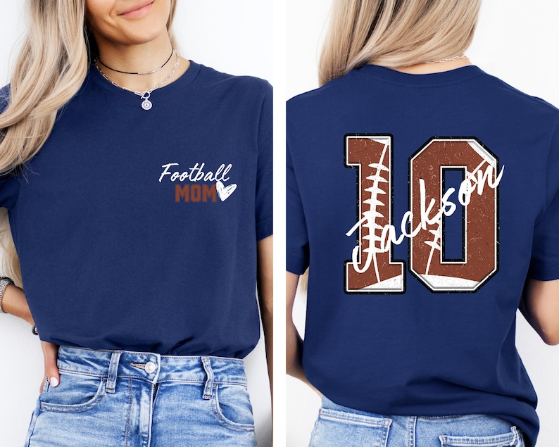 May include: Two navy blue t-shirts. The front of one shirt says "Football Mom" with a heart. The back of the other shirt has a large number 10 with the word "Jackson" written inside the number. The number is made to look like a football.