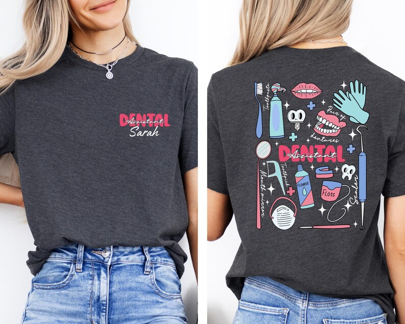 May include: A dark grey t-shirt with a pink and white design that says "Dental Assistant Sarah" on the front and a colourful illustration of dental tools and equipment on the back.