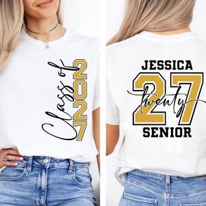 May include: White t-shirt with "Class of 2027" in black script and gold block letters on the front. The back of the shirt features the name "Jessica", the number "27", and the word "Senior" in black and gold.