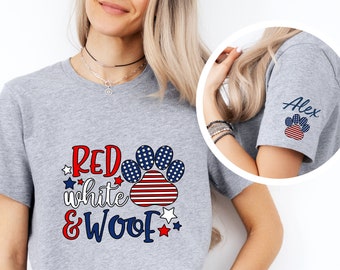 May include: Gray t-shirt with a red, white, and blue paw print and the text "RED white & WOOF". The paw print has stars and stripes. The shirt also has a small red, white, and blue star on the sleeve.