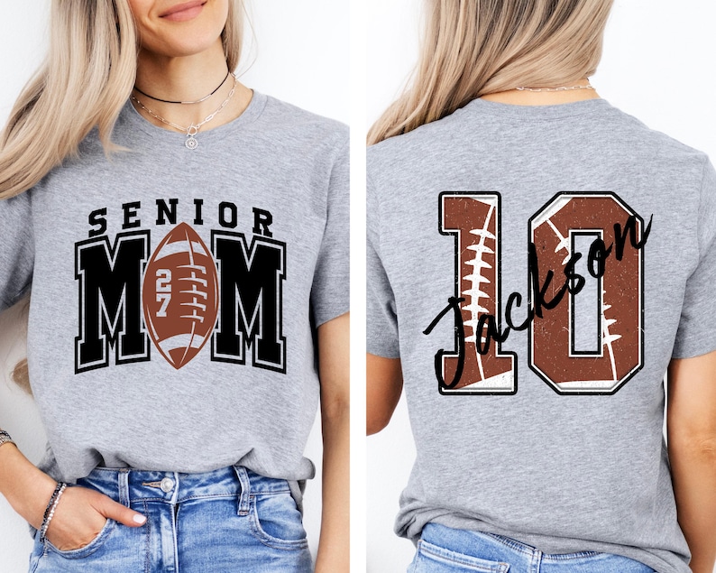 May include: A heather gray t-shirt featuring a front graphic with the text SENIOR MOM and a football replacing the letter O. The back graphic displays the number 10 with a football texture and the name Jackson written in black script across it.
