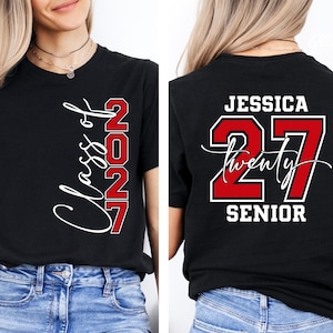 May include: Black t-shirt with "Class of 2027" in white script and red block letters. The back of the shirt features the name "Jessica", the number "27", and the word "Senior" in white and red.