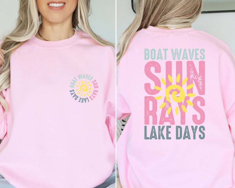 May include: Pink sweatshirt with a graphic design of a sun with the text "Boat Waves Sun Rays Lake Days" on the front and back.