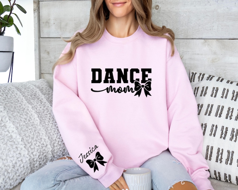 Pu&ograve; includere: Felpa rosa con la scritta "Dance Mom" e un fiocco nero. La felpa ha un fiocco nero sulla manica sinistra con la scritta "Jessica".
