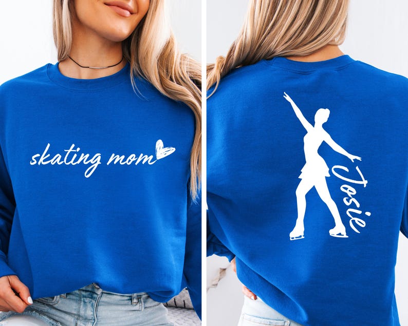 May include: A royal blue sweatshirt with the text "skating mom" and a small heart on the front. The back of the sweatshirt features a white silhouette of a figure skater with the name "Josie" written next to it.
