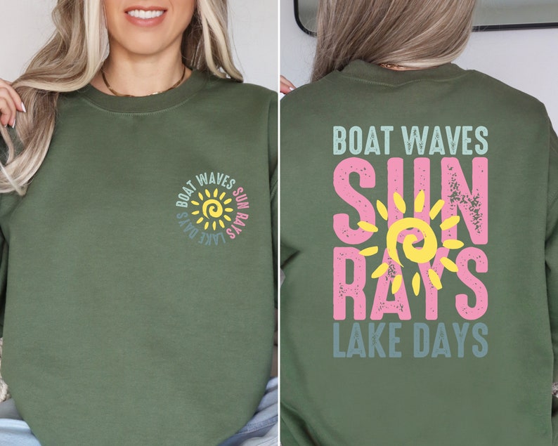 May include: A green long-sleeved sweatshirt with a sun graphic and the text "Boat Waves Sun Rays Lake Days" on the front and back.
