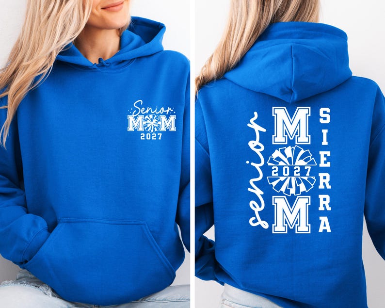 May include: A royal blue hoodie with white text and a front pocket. The front of the hoodie says "Senior Mom 2027" with a cheerleader graphic. The back of the hoodie says "Senior Mom Sierra 2027" with a cheerleader graphic.