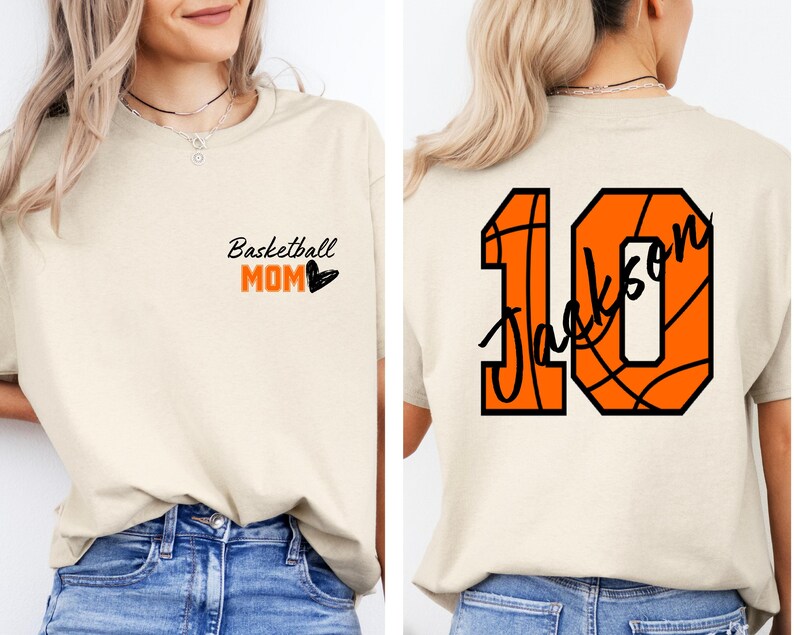Peut inclure: Un t-shirt beige avec le texte "Basketball Mom" et un c&oelig;ur sur le devant. Le dos du t-shirt a un num&eacute;ro 10 sur le th&egrave;me du basketball avec le nom "Jackson" &eacute;crit &agrave; l'int&eacute;rieur du ballon de basket.
