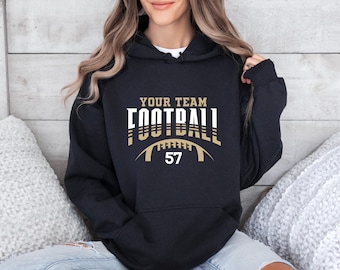 May include: Black hooded sweatshirt with a white and gold graphic design that says "Your Team Football" with a football graphic and the number 57.