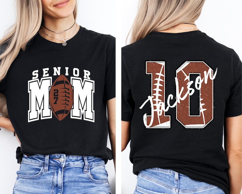May include: A black t-shirt featuring a front graphic with the text SENIOR MOM and a brown football with the number 27. The back graphic displays the number 10 with a football texture and the name Jackson written in white script across the center.
