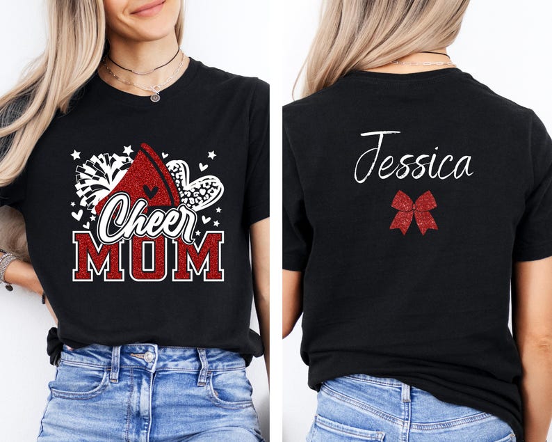 Puede incluir: Camiseta negra con texto rojo de purpurina que dice "Cheer Mom" y un pomp&oacute;n rojo y blanco de purpurina. La parte posterior de la camiseta tiene el nombre "Jessica" en purpurina blanca y un lazo rojo de purpurina.