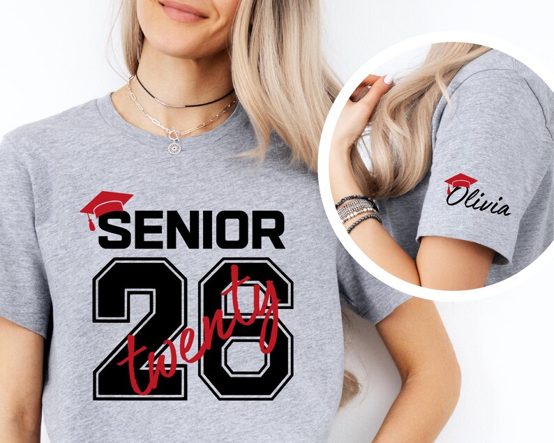 May include: A light gray t-shirt with the word "SENIOR" above the number "20" in a black and red design. The sleeve has a small red graduation cap and the name "Olivia" in black script.