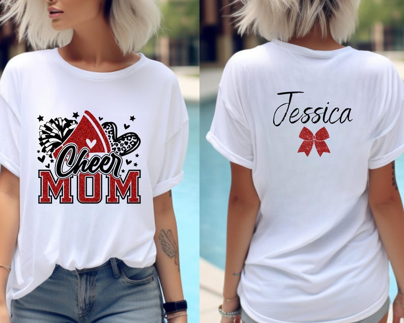 Puede incluir: Camiseta blanca con un dise&ntilde;o rojo, negro y blanco que dice "Cheer Mom" en la parte delantera. La parte posterior de la camiseta tiene un lazo rojo y el nombre "Jessica" en negro.