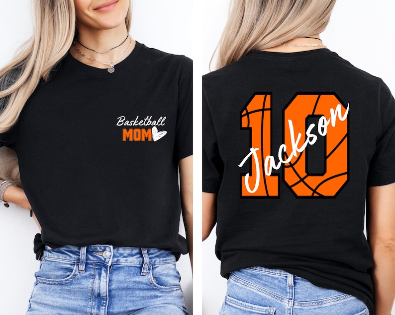 Peut inclure: T-shirt noir avec le texte "Basketball Mom" et un c&oelig;ur sur le devant. Le dos du t-shirt a un num&eacute;ro 10 en forme de ballon de basket avec le nom "Jackson" &eacute;crit &agrave; l'int&eacute;rieur.