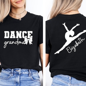 May include: Black t-shirt with white text that says "DANCE grandma" with a white bow. The back of the shirt has a white silhouette of a dancer with the name "Elizabeth" written below.