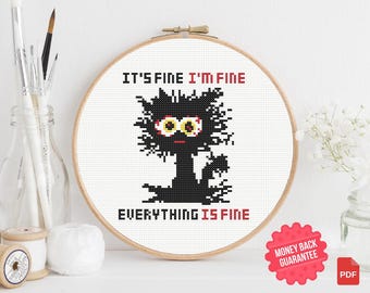 May include: Cross-stitch embroidery in a wooden hoop features a black cat with wide yellow eyes and the text "IT'S FINE I'M FINE EVERYTHING IS FINE" in red. The design is on a white background.