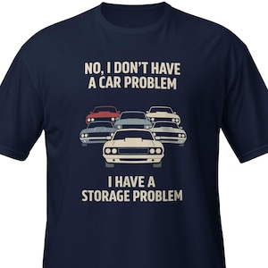 May include: Navy blue t-shirt featuring a graphic of five classic cars in red, white, and blue. The text on the shirt says, "NO, I DON'T HAVE A CAR PROBLEM, I HAVE A STORAGE PROBLEM."