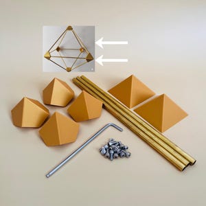 Op de afbeelding: Een set goudkleurige metalen onderdelen voor een geometrische structuur, inclusief zes piramidevormige verbindingsstukken, drie lange staven, een kleine hoop zilverkleurige schroeven en een L-vormige inbussleutel. Een afbeelding toont de gemonteerde structuur.