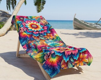 Puede incluir: Una toalla de playa colorida con un patrón floral en tonos de rosa, azul, amarillo y verde. La toalla está drapeada sobre una silla de playa de madera.