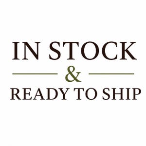May include: A graphic design featuring the dark brown text IN STOCK on the top line, a centered olive green ampersand symbol flanked by two horizontal lines, and the dark brown text READY TO SHIP on the bottom line against a white background.
