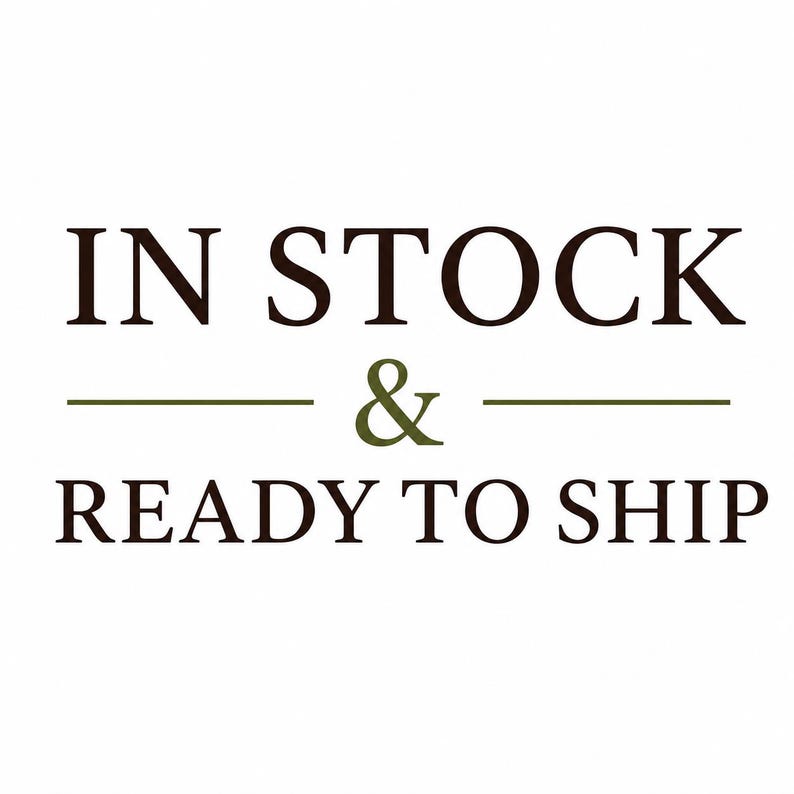 May include: A graphic design featuring the dark brown text IN STOCK on the top line, a centered olive green ampersand symbol flanked by two horizontal lines, and the dark brown text READY TO SHIP on the bottom line against a white background.