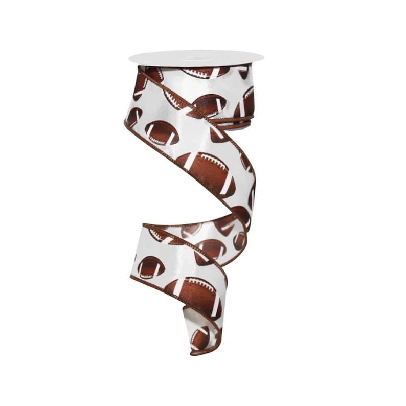 May include: A spool of white ribbon featuring a repeating pattern of brown American footballs with white laces. The ribbon has a wired edge in a matching brown color, allowing it to hold its shape when twisted into a spiral display.