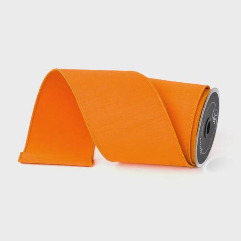 Puede incluir: Un rollo de cinta naranja brillante. La cinta es de color liso y tiene un aspecto texturizado. La bobina es negra con texto blanco. Esta cinta es adecuada para manualidades, envolver regalos y decoraciones.