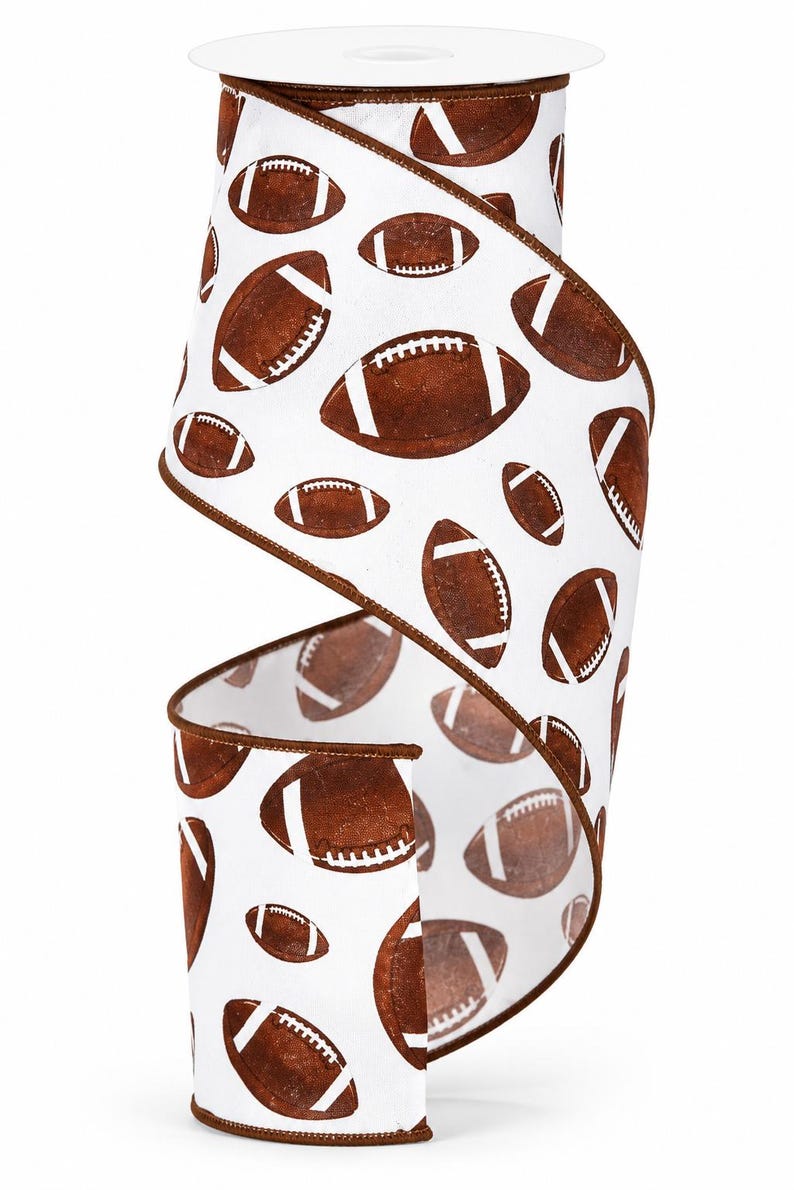 May include: A roll of white wired ribbon featuring a repeating pattern of brown American footballs with white laces. The ribbon has a dark brown stitched edge along both sides, providing a defined border to the fabric material throughout the roll.