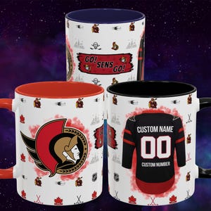 May include: Three white ceramic mugs with hockey-themed designs. One mug has a red interior and handle, featuring the Ottawa Senators logo. Another has a black interior and handle, with a jersey design. The third mug has a blue interior.