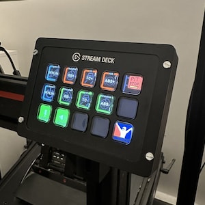 Könnte beinhalten: Ein schwarzes Stream Deck mit einem Raster aus 15 Tasten. Die Tasten sind mit Text und Symbolen beschriftet, darunter "OFFLIN", "BB+", "TC+", "ABS+", "PIT STOP", "OFFLIN", "BB-", "TC-", "ABS-", "SWITCH", "VOLUME" und eine Figur einer Person mit ausgestreckten Armen.