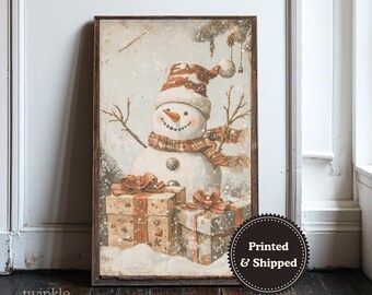 May include: A framed print featuring a snowman wearing a hat and scarf, with twig arms and a carrot nose. Two wrapped gifts with bows are at the base of the snowman. The print has a vintage, snowy aesthetic.