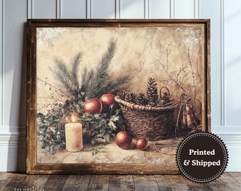 May include: A framed print featuring a still life with a candle, apples, pinecones in a basket, and greenery. The artwork has a rustic, vintage aesthetic with warm tones. The print is labeled "twinkle & tonic" and "Printed & Shipped".