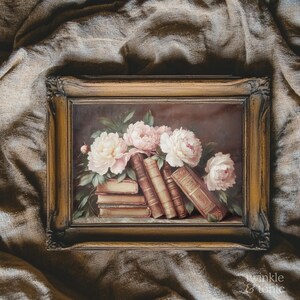 May include: A framed painting featuring a still life of books and flowers. The artwork depicts a stack of old books with light pink and white peonies. The frame is a warm, antique gold color, adding to the vintage aesthetic.