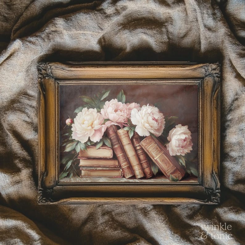 May include: A framed painting featuring a still life of books and flowers. The artwork depicts a stack of old books with light pink and white peonies. The frame is a warm, antique gold color, adding to the vintage aesthetic.
