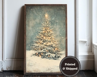 May include: A framed print of a Christmas tree covered in snow, lit with warm lights, and topped with a star. The artwork has a vintage, distressed look, with a dark wooden frame. The words "Printed & Shipped" are on a circular sticker.