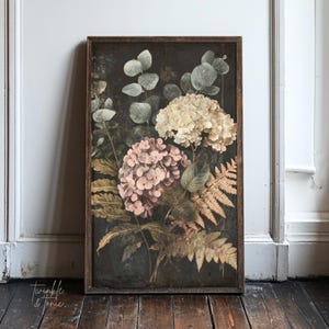 May include: A framed botanical print featuring a dark background with a vintage aesthetic. The artwork showcases a cluster of hydrangeas in soft pink and cream hues, complemented by green eucalyptus leaves and golden ferns. The frame is a dark brown.