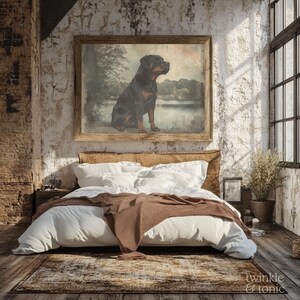 May include: A framed artwork featuring a Rottweiler dog sitting by a lake, hanging above a bed with white bedding and a brown throw. The room has a rustic, vintage aesthetic with exposed brick and a large window.