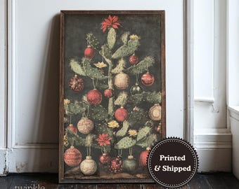 May include: A framed print featuring a cactus decorated as a Christmas tree. The artwork showcases a dark background with a prickly pear cactus adorned with red, gold, and green ornaments. The print has a dark brown frame and the text "twinkle & tonic" is in the lower left corner.