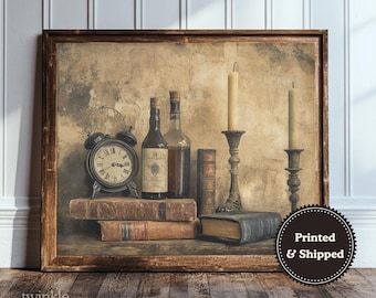 May include: A framed wall art print featuring a still life composition with a black alarm clock, two glass bottles, two tall candles in metal holders, and three leather-bound books. The scene is set against a textured, neutral-toned background.