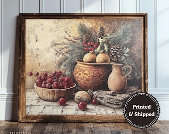 May include: A framed print of a still life arrangement featuring a wooden bowl of red grapes, a decorative pot, and a small pitcher. The artwork includes pine cones, berries, and greenery, with a rustic, vintage aesthetic. The frame is brown.