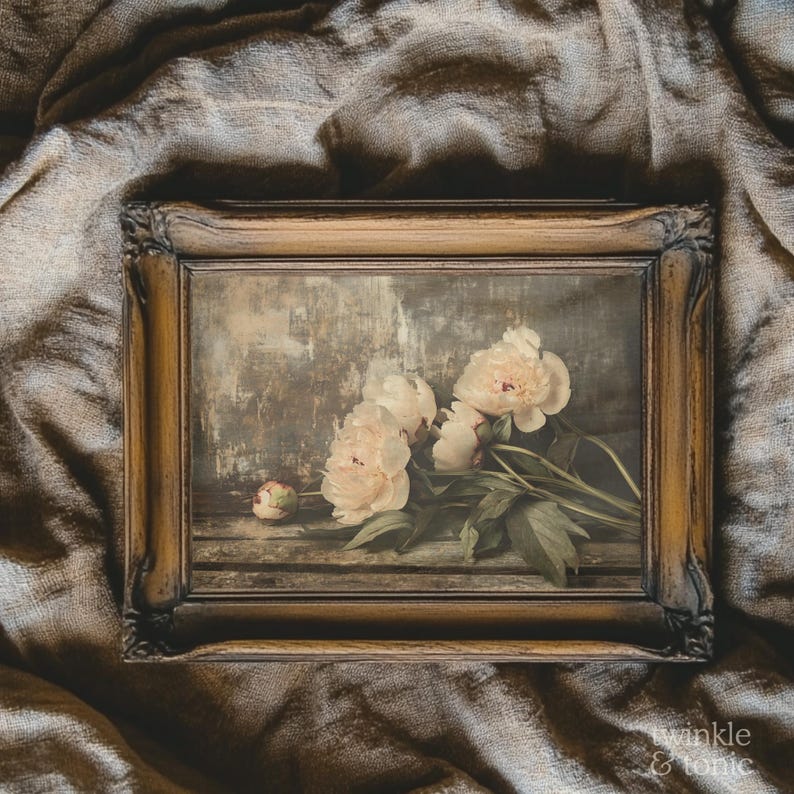 May include: A framed floral print featuring soft pink peonies with green leaves. The artwork has a vintage aesthetic, with a distressed wooden frame and a muted color palette. The background is a textured, neutral tone.