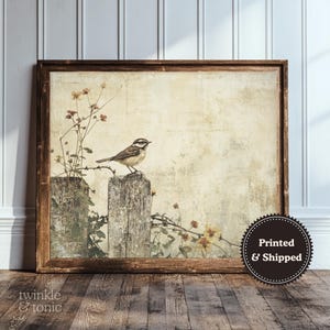 May include: A framed print featuring a vintage-style illustration of a small bird perched on a weathered wooden post. The artwork has a neutral color palette with muted tones, and includes the text "twinkle & tonic".