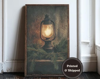 May include: A framed print featuring a vintage lantern with a glowing light, set against a rustic wooden background. The lantern is surrounded by evergreen branches, creating a warm, inviting scene. The print has a dark brown frame.