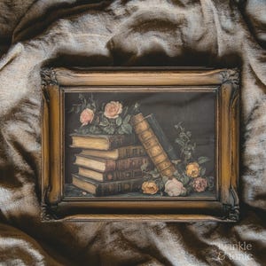 Puede incluir: Una impresi&oacute;n vintage enmarcada que presenta una naturaleza muerta de libros antiguos y rosas. Los libros, con cubiertas doradas, est&aacute;n apilados e inclinados. Rosas rosas y amarillas con hojas verdes est&aacute;n dispuestas alrededor de los libros. El marco es ornamentado y dorado.
