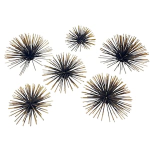 May include: A collection of six decorative metal starburst sculptures. Each starburst features a dark, almost black, central sphere with radiating gold-toned spikes. The sculptures vary slightly in size and are arranged against a white background.