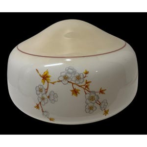 May include: A dome-shaped white glass light fixture shade featuring a smooth, rounded top and a decorative floral pattern. The design displays a branch with light gray blossoms and vibrant yellow leaves encircling the side of the glass.