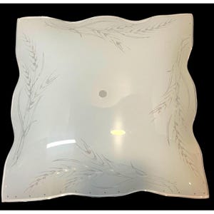 May include: A square, frosted glass light fixture cover with wavy, scalloped edges. The surface features a delicate, etched pattern of wheat stalks extending from the corners toward the center, which has a circular hole for mounting hardware.