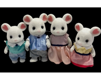 May include: Four white mouse figurines with pink-lined ears. The mice are dressed in various outfits: a blue and white checkered outfit, a blue satin shirt with checkered pants, a pink dress, and a pink and yellow dress. The figurines are set against a black background.